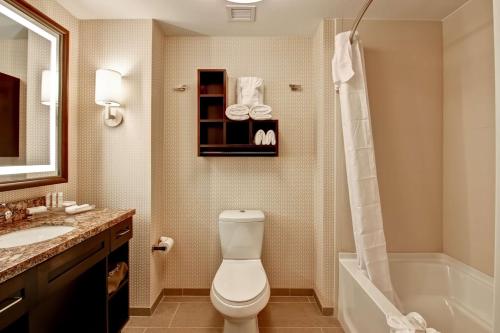 a bathroom with a toilet and a tub and a sink at Homewood Suites by Hilton Palo Alto in Palo Alto