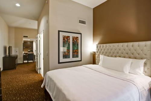 a hotel room with a large bed with white sheets at Homewood Suites by Hilton Palo Alto in Palo Alto