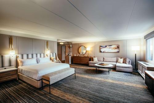 a hotel room with a bed and a living room at Somerset Hills Hotel, Tapestry Collection by Hilton in Basking Ridge