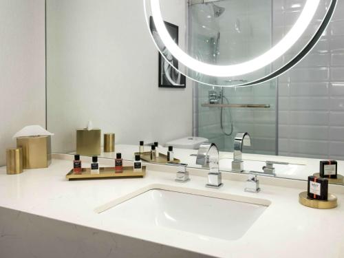 a bathroom with a sink and a mirror at Somerset Hills Hotel, Tapestry Collection by Hilton in Basking Ridge