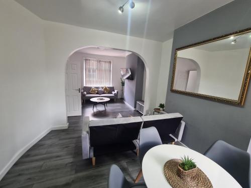 a living room with a table and a mirror at Lovely 2-bedroom house close to Media City. in Manchester