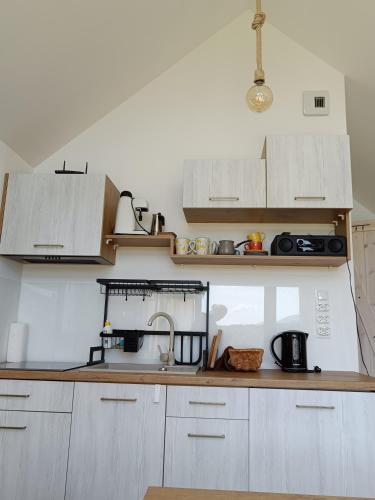 a kitchen with white cabinets and a sink at Pod Gwiazdami in Cisna
