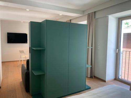 a green cabinet in a bedroom with a window at Wellness Smart Suites in Bolzano