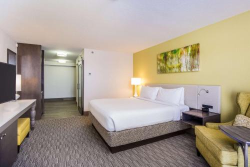 a hotel room with a white bed and a couch at Hilton Garden Inn Orange Beach in Orange Beach