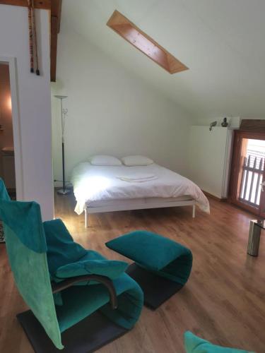 a bedroom with a bed and a green chair at La Bergerie in La Neuveville