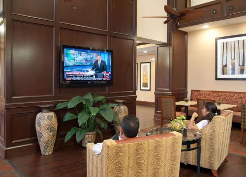 two people sitting in a lobby watching a television at Hampton Inn & Suites New Braunfels in New Braunfels