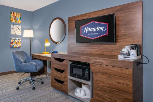 a room with a desk and a mirror and a chair at Hampton Inn & Suites Hopkinsville in Hopkinsville