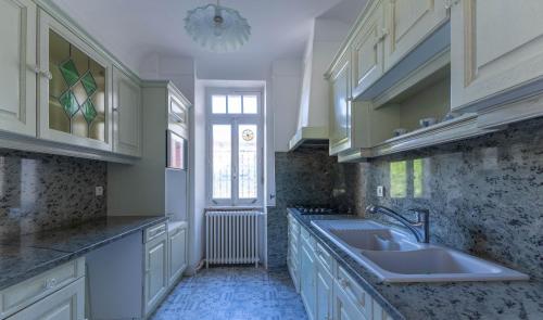 a large kitchen with a sink and a window at Ma Tranquillite in Courpière