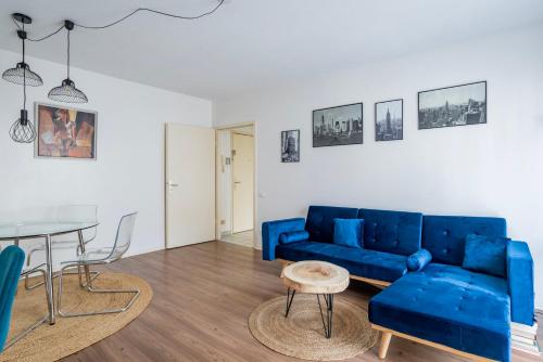 un salon avec un canapé bleu et une table dans l'établissement Le Schiffslitt - Hyper-Centre, Proche des Quais, à Strasbourg