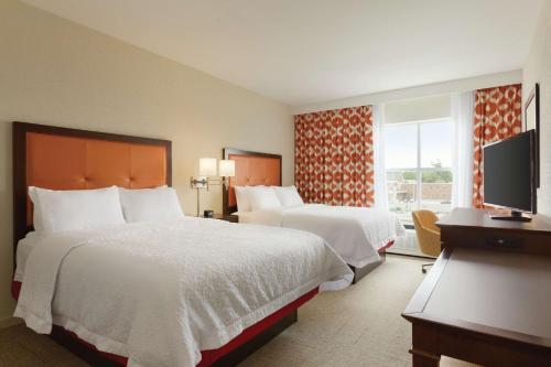 聖奧爾本斯的住宿－Hampton Inn, St. Albans Vt，酒店客房设有两张床和电视。