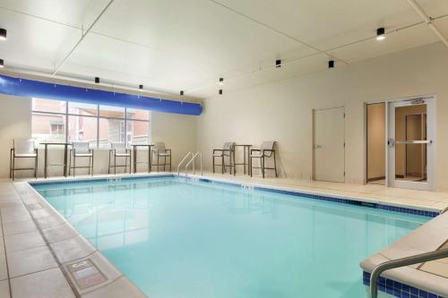 a large swimming pool with chairs in a building at Hampton Inn, St. Albans Vt in Saint Albans
