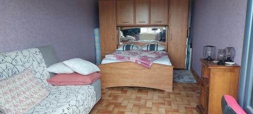 a bedroom with a bed and a dresser with a mirror at Chambres chez l habitant proches circuit Magny Cours in Luthenay-Uxeloup