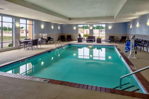 uma piscina num quarto de hotel com mesas e cadeiras em Hampton Inn Arkadelphia em Arkadelphia