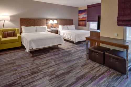 a hotel room with two beds and a desk at Hampton Inn Arkadelphia in Arkadelphia