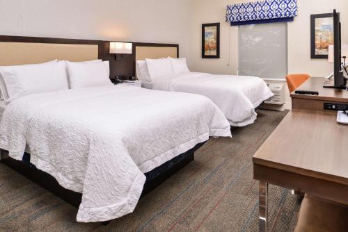 a hotel room with two beds and a desk at Hampton Inn Benson in Benson