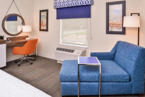 a living room with a blue couch and a desk at Hampton Inn Benson in Benson
