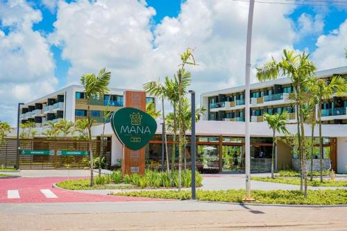 Mana Beach Muro Alto Resort في بورتو دي غالينهاس: مبنى مع علامة أمامه