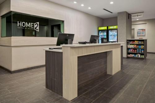 a lobby of a store with two laptops on a counter at Home2 Suites By Hilton Rowlett Rockwall Marina in Rowlett