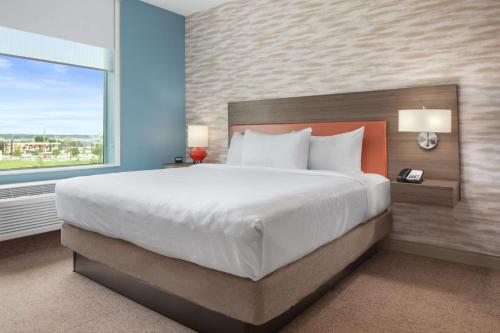 a bedroom with a large bed and a large window at Home2 Suites By Hilton Rowlett Rockwall Marina in Rowlett