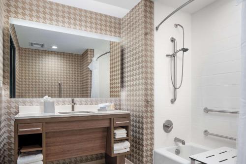 W łazience znajduje się umywalka, wanna i lustro. w obiekcie Home2 Suites By Hilton Rowlett Rockwall Marina w mieście Rowlett