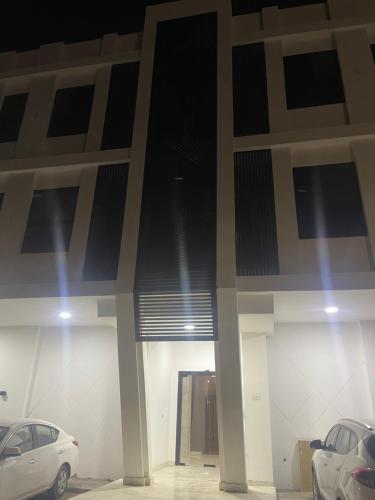 un estacionamiento con dos autos estacionados en él en One Bedroom Al Hail DT, en Ḩayl Āl ‘Umayr