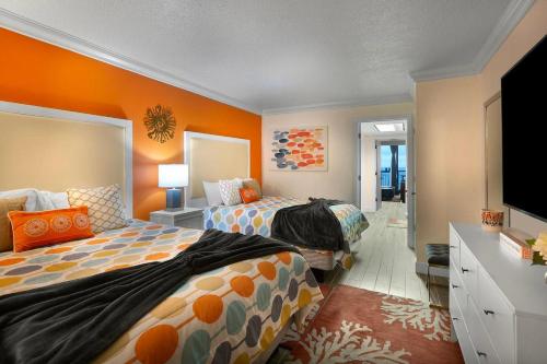 a bedroom with two beds and a flat screen tv at Oceanfront Condo with Amazing Oceanfront Views in Myrtle Beach