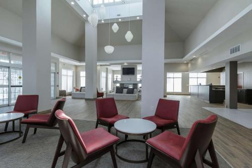 a lobby with red chairs and tables and a living room at Hilton Garden Inn Elkhart in Elkhart
