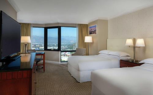 ロサンゼルスにあるヒルトン ロサンゼルス ユニバーサル シティーのベッド2台、薄型テレビが備わるホテルルームです。