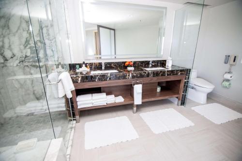 a bathroom with a sink and a mirror and a toilet at Hilton Los Angeles-Universal City in Los Angeles