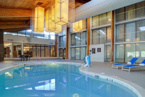 a large swimming pool in a building with blue chairs at Doubletree by Hilton Harrisonburg in Harrisonburg