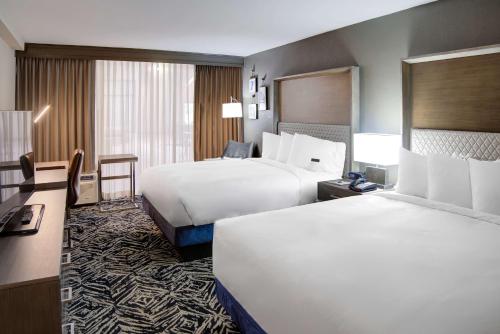 a hotel room with two beds and a desk at Doubletree by Hilton Harrisonburg in Harrisonburg