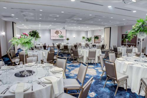 a banquet room with white tables and chairs at Doubletree by Hilton Harrisonburg in Harrisonburg