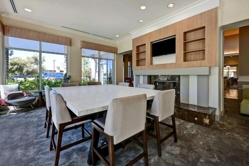 a dining room with a large white table and chairs at Hilton Garden Inn San Bernardino in San Bernardino