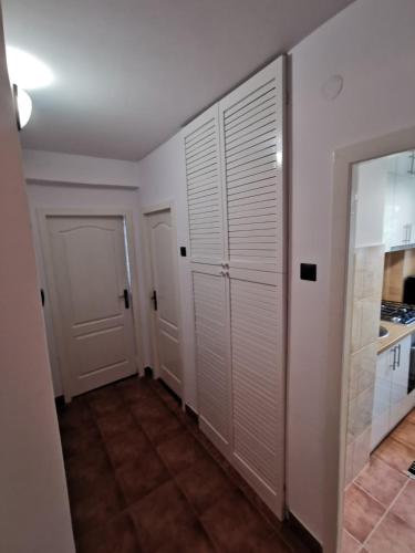 a hallway with white closet doors and a kitchen at Apartament Ocnele Mari in Ocnele Mari