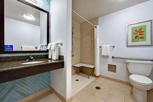 a bathroom with a toilet and a sink and a mirror at Hilton Garden Inn San Bernardino in San Bernardino