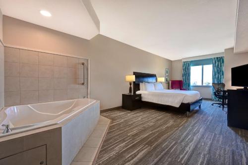 a hotel room with a bed and a bath tub at Hilton Garden Inn San Bernardino in San Bernardino