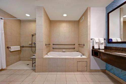 ein Bad mit einer Badewanne, einer Dusche und einem Waschbecken in der Unterkunft Hilton Garden Inn San Bernardino in San Bernardino