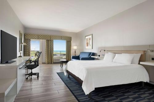 um quarto de hotel com uma cama e uma televisão em Hilton Garden Inn South Padre Island em South Padre Island