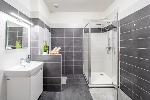 a bathroom with a sink and a shower at Wellness Hotel Frymburk Apartmány in Frymburk