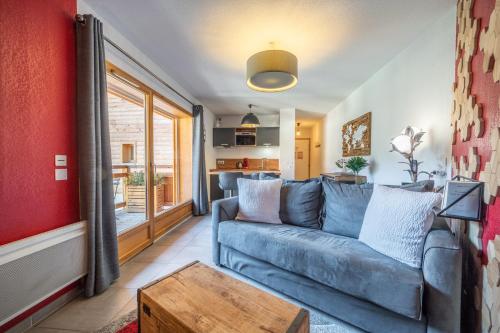 un salon avec un canapé bleu et une table dans l'établissement Studio au cœur du village, à Saint-Jean-de-Sixt