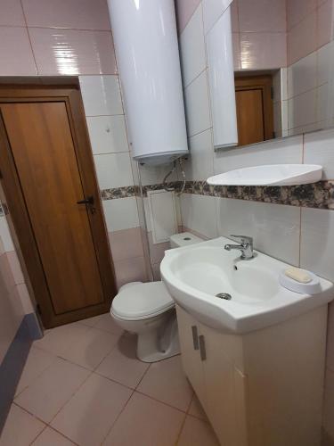 a bathroom with a sink and a toilet and a mirror at Нощувки Краткосрочен наем in Plovdiv