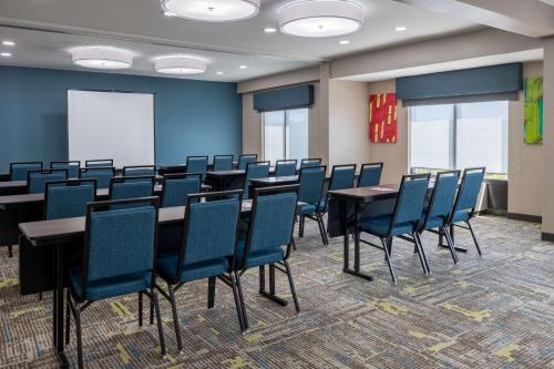 a conference room with tables and chairs and a whiteboard at Hampton Inn & Suites Alpharetta Roswell in Alpharetta