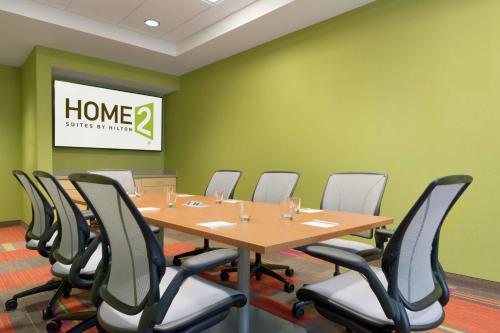 a conference room with a wooden table and chairs at Home2 Suites by Hilton Durham Chapel Hill in Durham