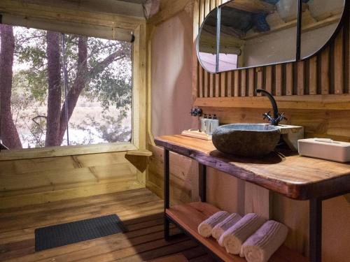 a bathroom with a sink and a mirror at Bundox River Lodge in Hoedspruit