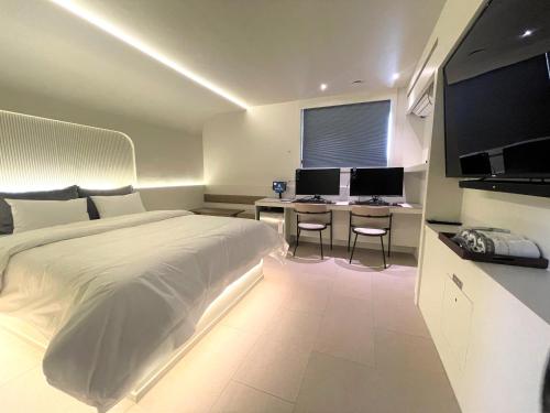 1 dormitorio con 1 cama y escritorio con 2 monitores en D'you Hotel, en Gwangju