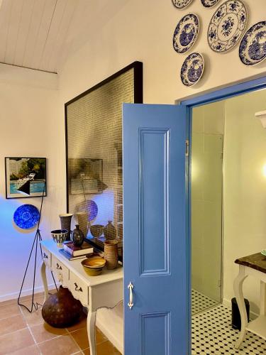 a blue door in a room with plates on the wall at 1 Royal Street Guesthouse in Riebeek-Kasteel