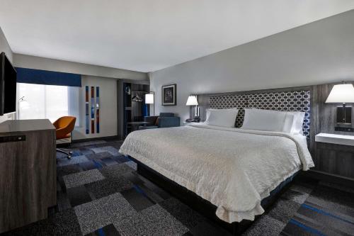 Habitación de hotel con cama grande y escritorio. en Hampton Inn San Antonio Downtown en San Antonio