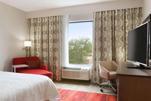 a hotel room with a bed and a tv and a window at Hampton Inn By Hilton North Olmsted Cleveland Airport in North Olmsted