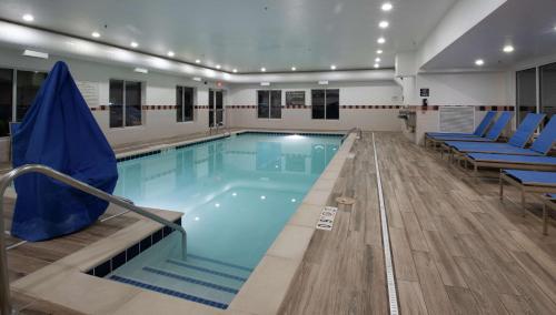 a swimming pool with blue chairs in a building at Hampton Inn & Suites Williamsburg-Richmond Road in Williamsburg