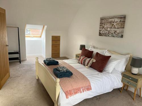 a bedroom with a large bed with pillows on it at Honeysuckle Barn, Martham in Great Yarmouth